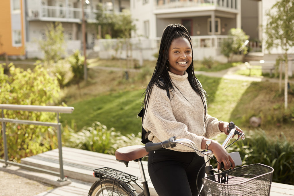 En tjej som står med en cykel